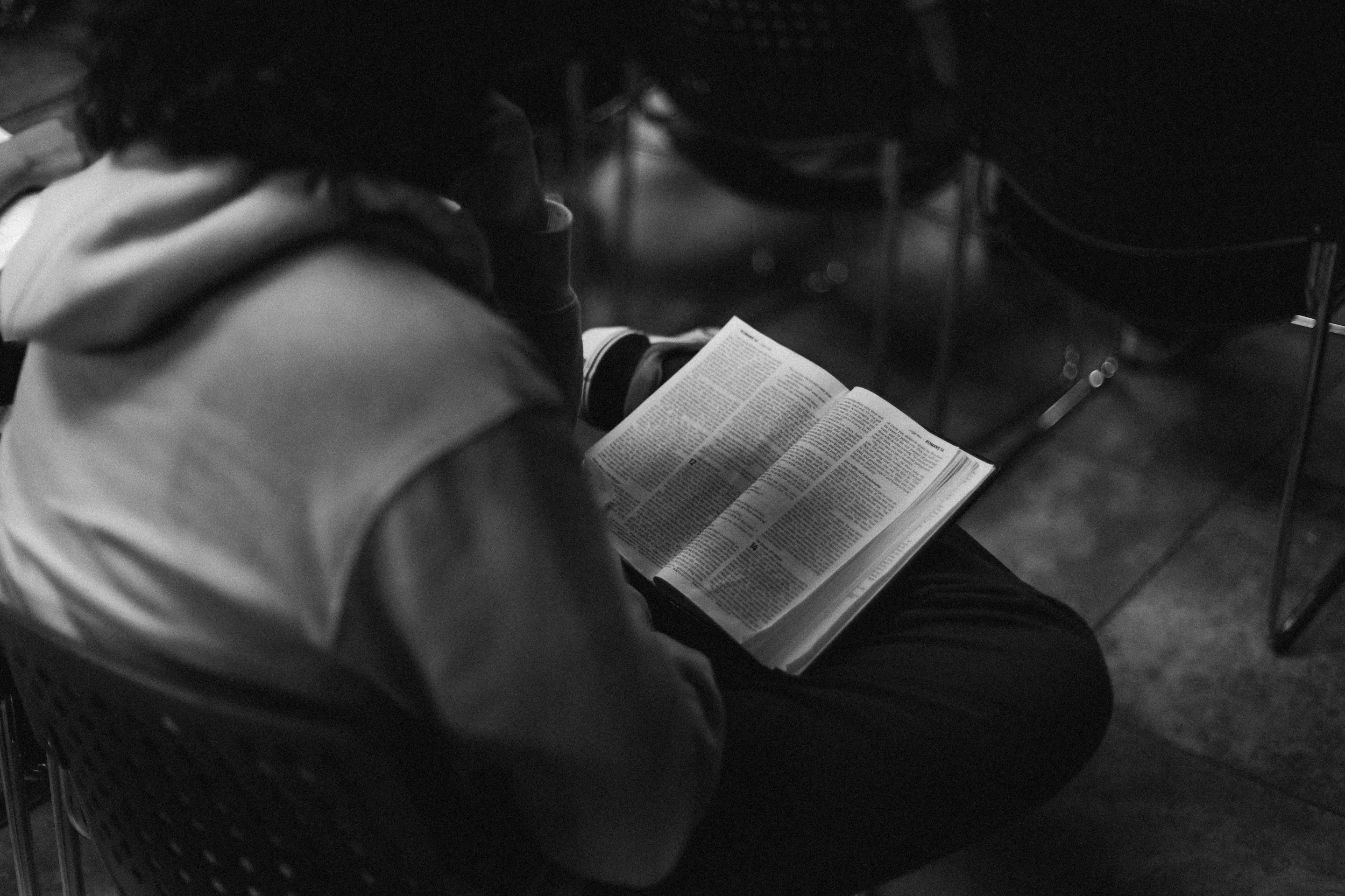 Una persona sentada leyendo la Biblia.