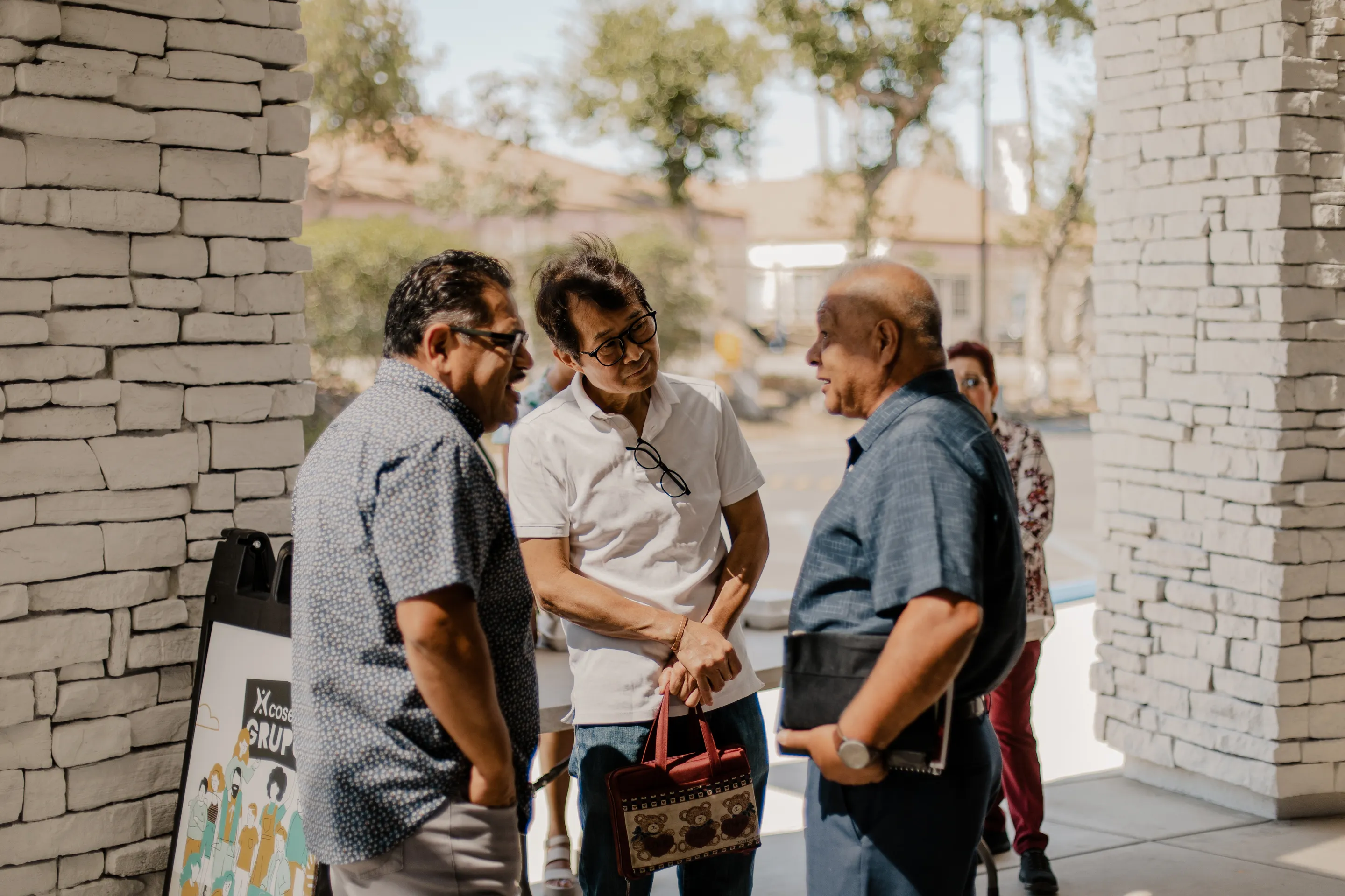 Un grupo de hombres hablando afuera de la iglesia.