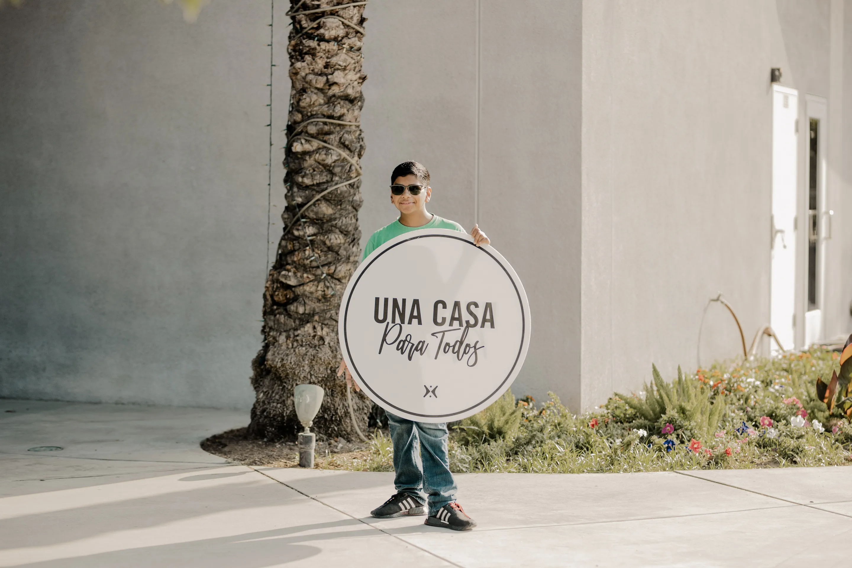 Un niño sosteniendo un cartel de bienvenida